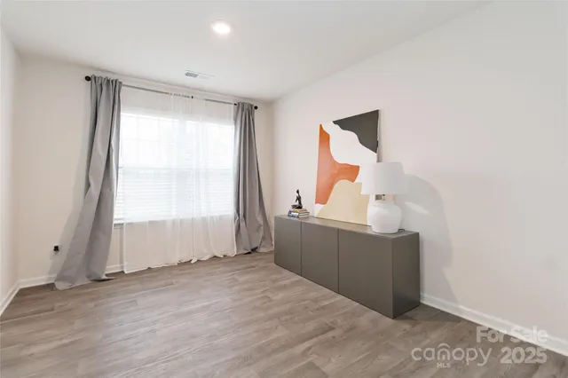 an empty room with wooden floor and window