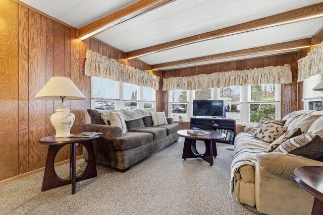 a living room with furniture a large window and a chandelier