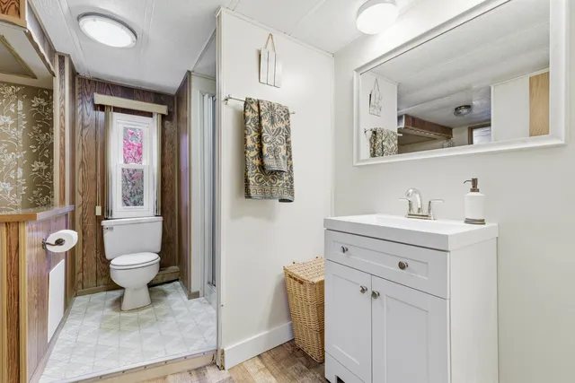 a view of bathroom with a sink mirror and toilet