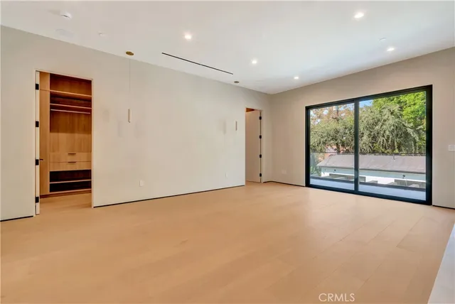 an empty room with windows & cabinet