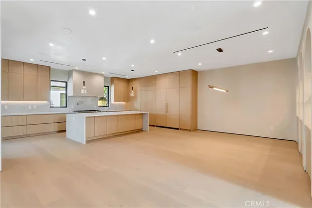 a view of kitchen with stainless steel appliances granite countertop a sink and a refrigerator