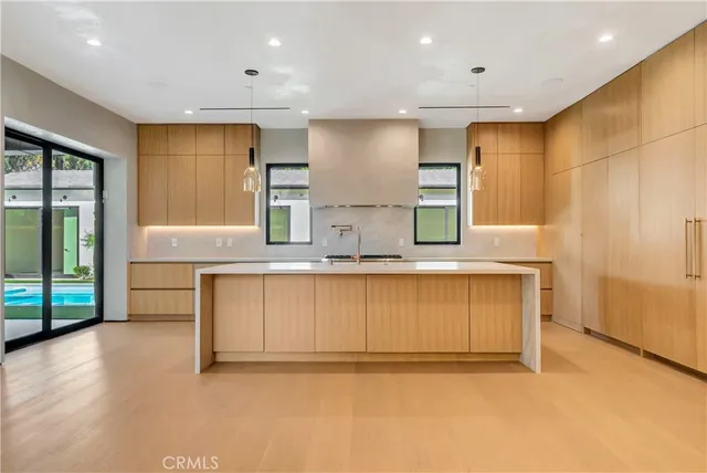 a large kitchen with stainless steel appliances kitchen island granite countertop a refrigerator and a stove