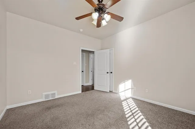 a view of a room with a ceiling fan and a window
