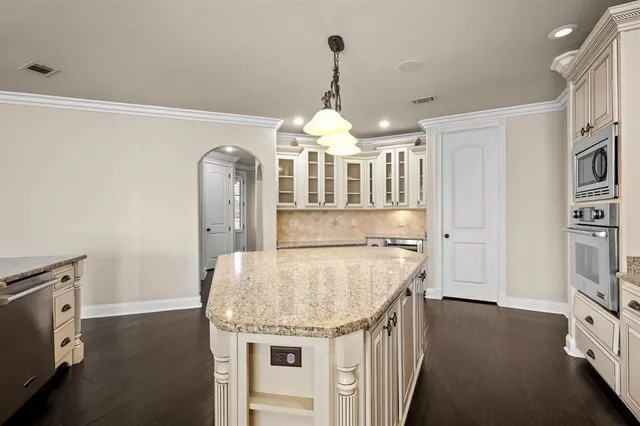 a kitchen with granite countertop a stove and a white kitchen island