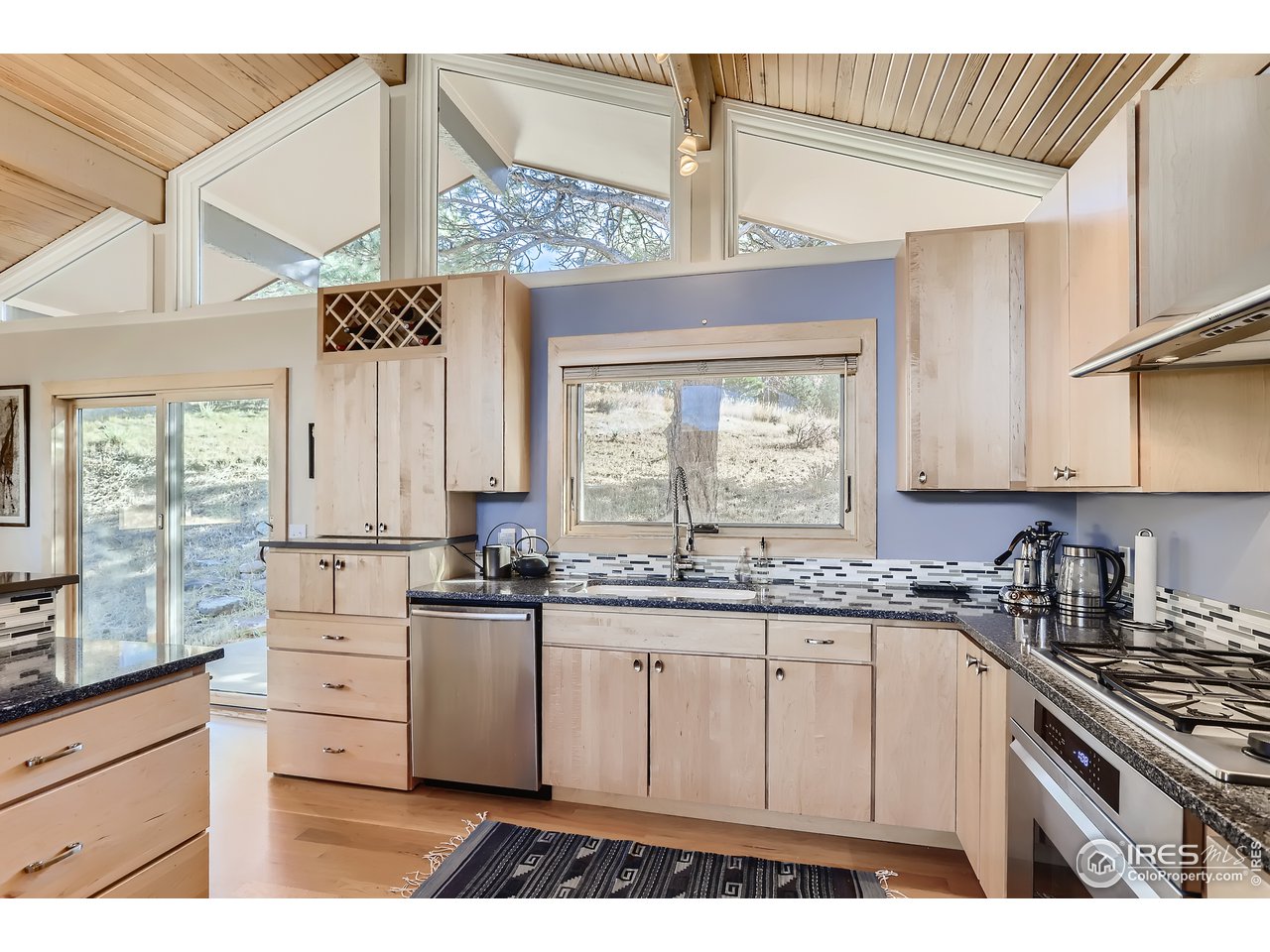 389 South Cedar Brook Road Boulder, CO 80304 - Photo 11 of 30 a kitchen with stainless steel appliances granite countertop a stove a sink dishwasher and white cabinets with wooden floor