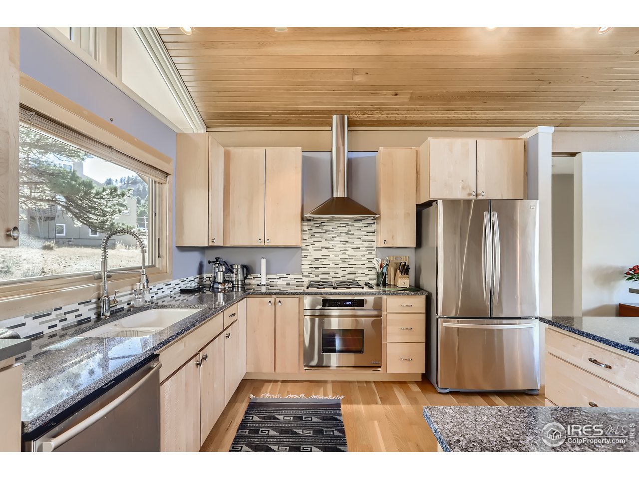 389 South Cedar Brook Road Boulder, CO 80304 - Photo 6 of 30 a kitchen with kitchen island granite countertop a sink cabinets stainless steel appliances and a large window