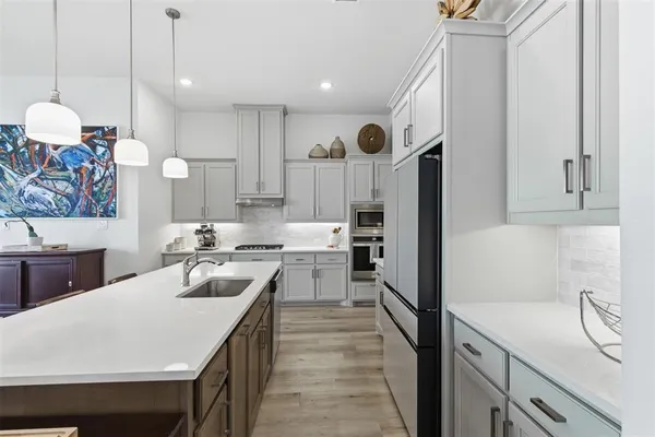 a kitchen with a sink a counter space and stainless steel appliances