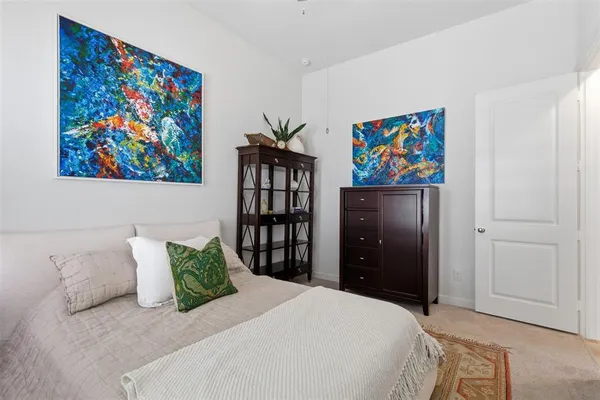 a bedroom with a bed and painting on the wall