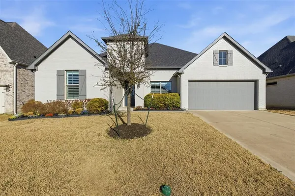 a front view of house with yard and trees around