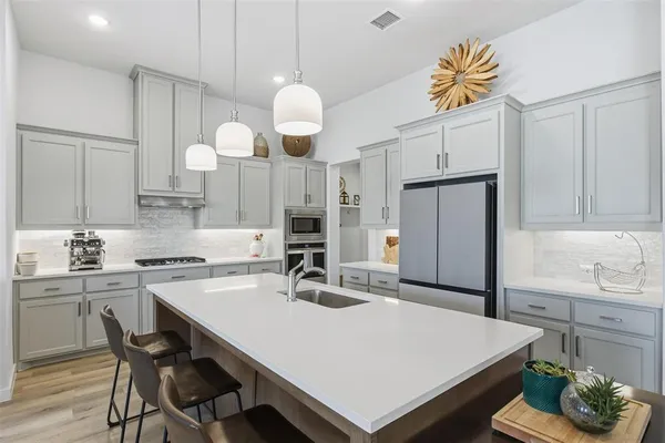 a kitchen with a table a sink and refrigerator