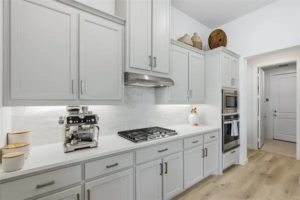 a kitchen with stainless steel appliances a sink a stove and cabinets