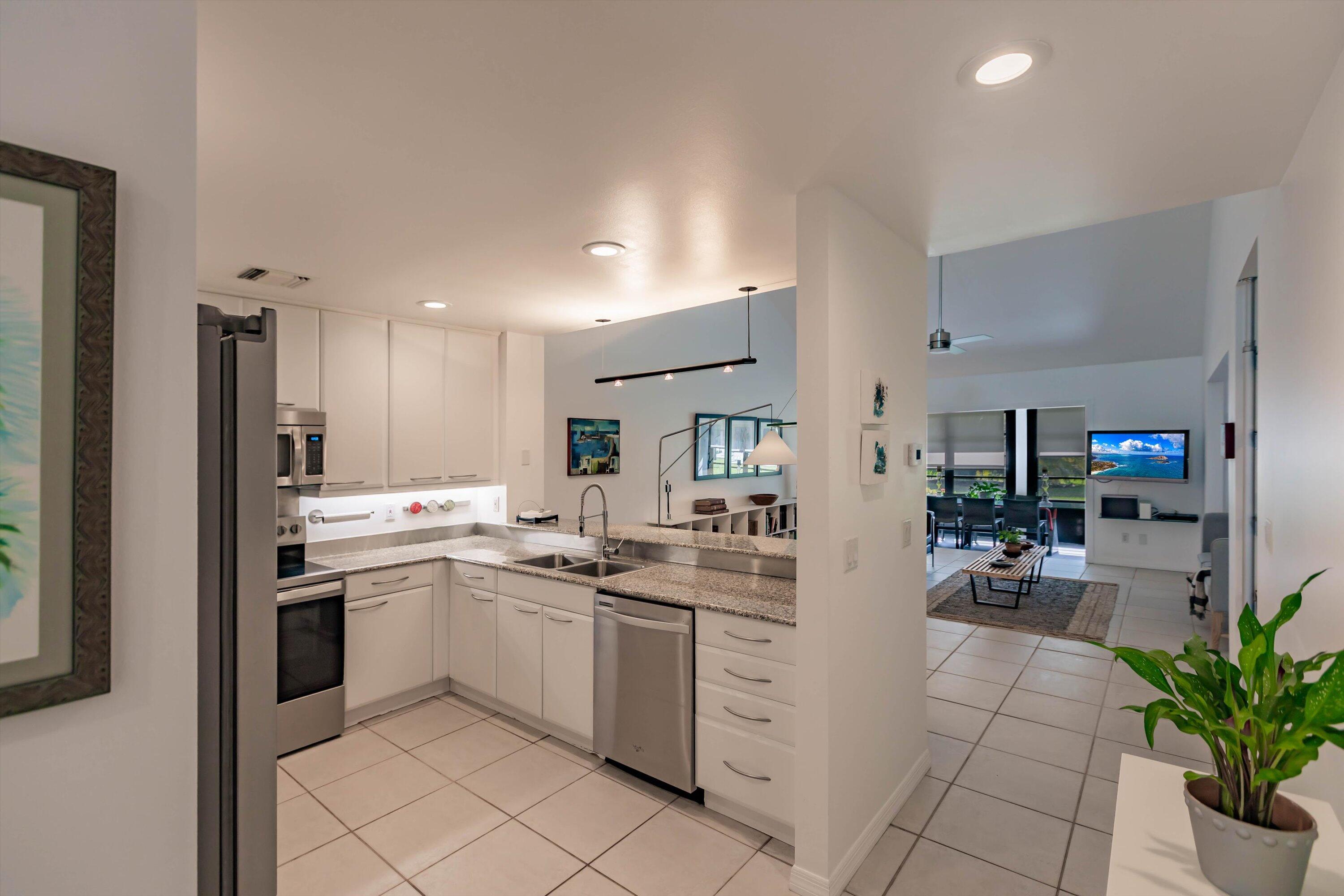 6115 Southeast Georgetown Place, Unit 1006 Hobe Sound, FL 33455 - Photo 16 of 68 a kitchen with a sink and white cabinets
