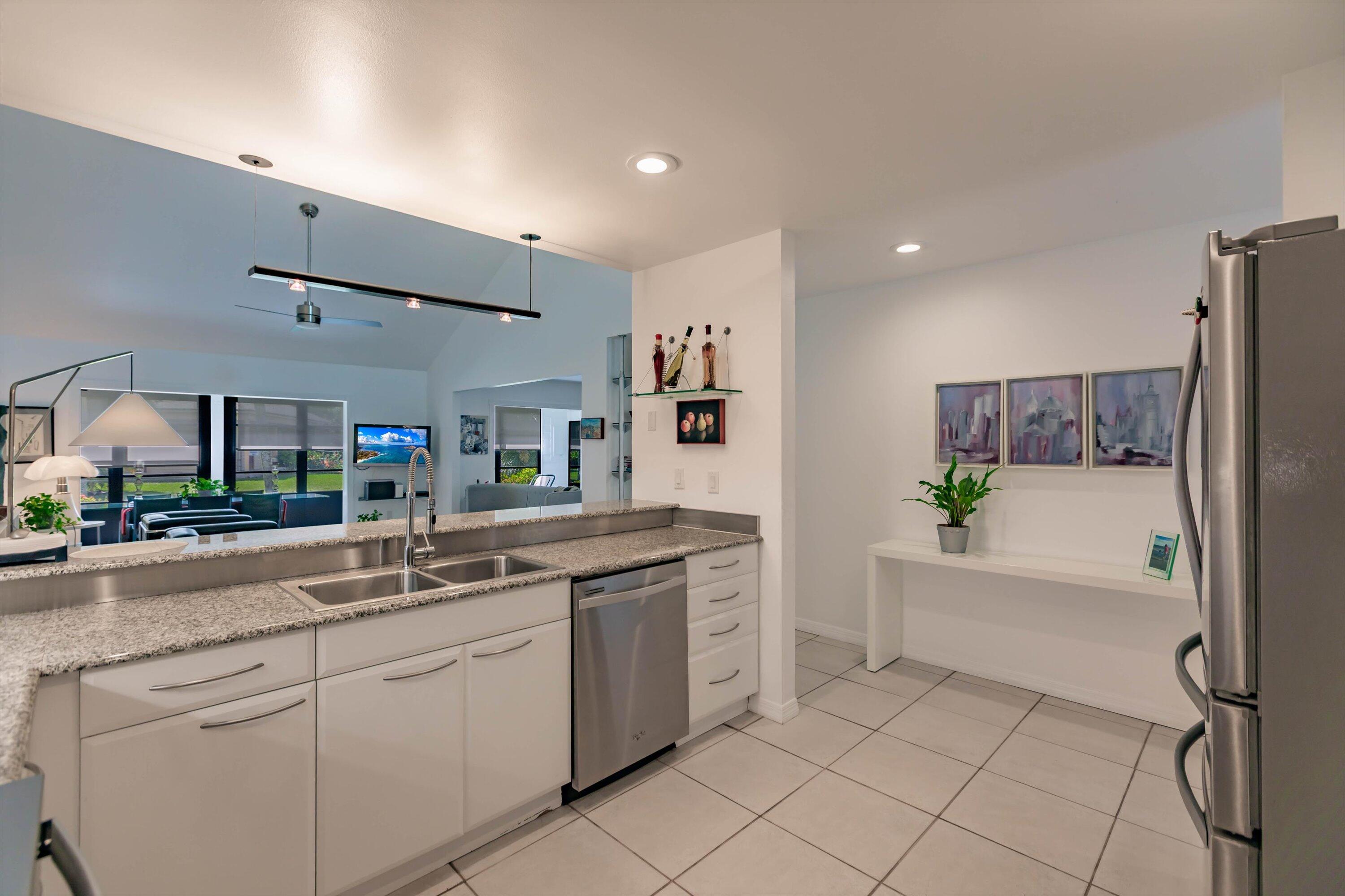 6115 Southeast Georgetown Place, Unit 1006 Hobe Sound, FL 33455 - Photo 18 of 68 a kitchen with a sink and refrigerator