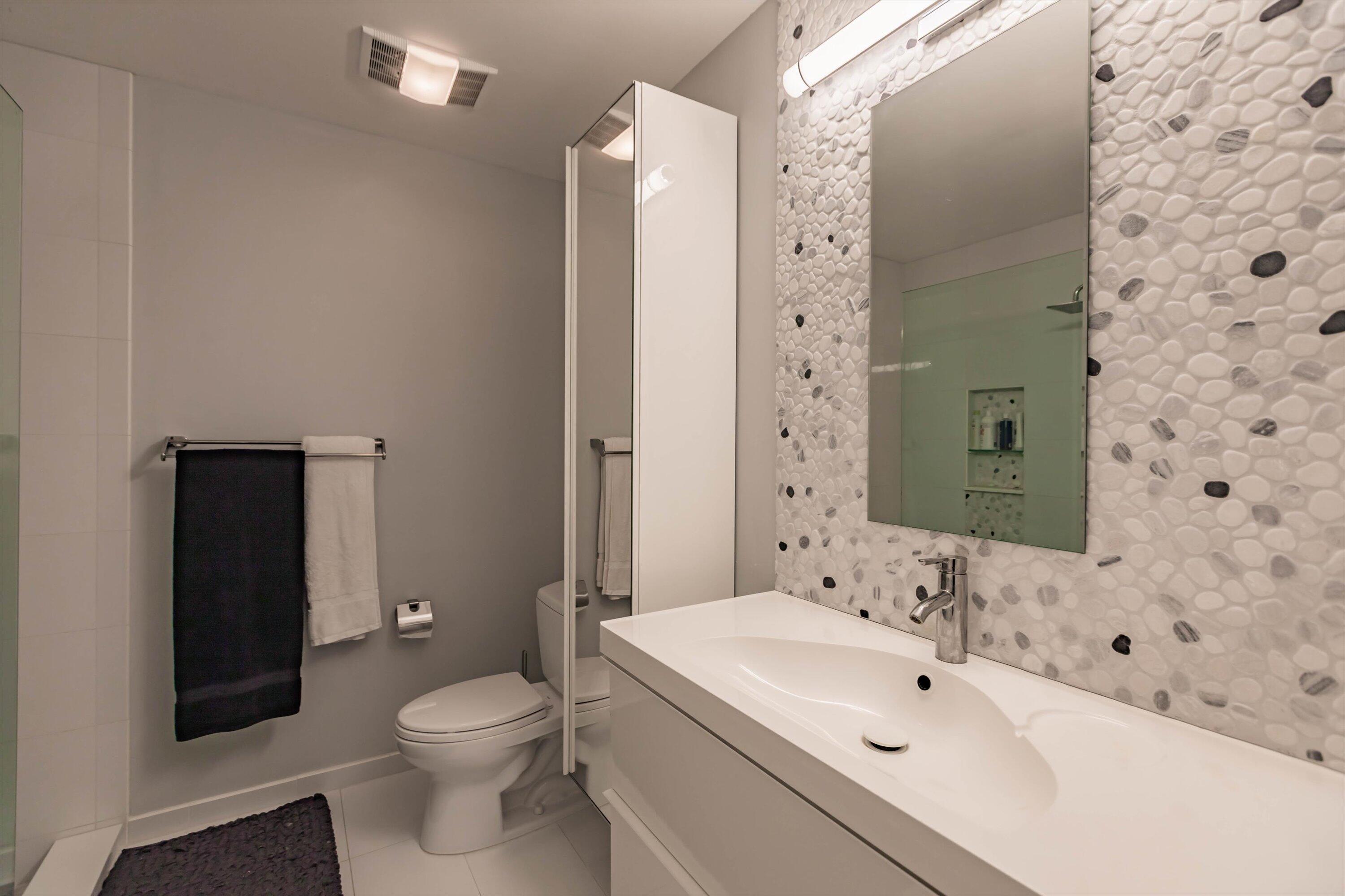 6115 Southeast Georgetown Place, Unit 1006 Hobe Sound, FL 33455 - Photo 21 of 68 a bathroom with a sink toilet and shower