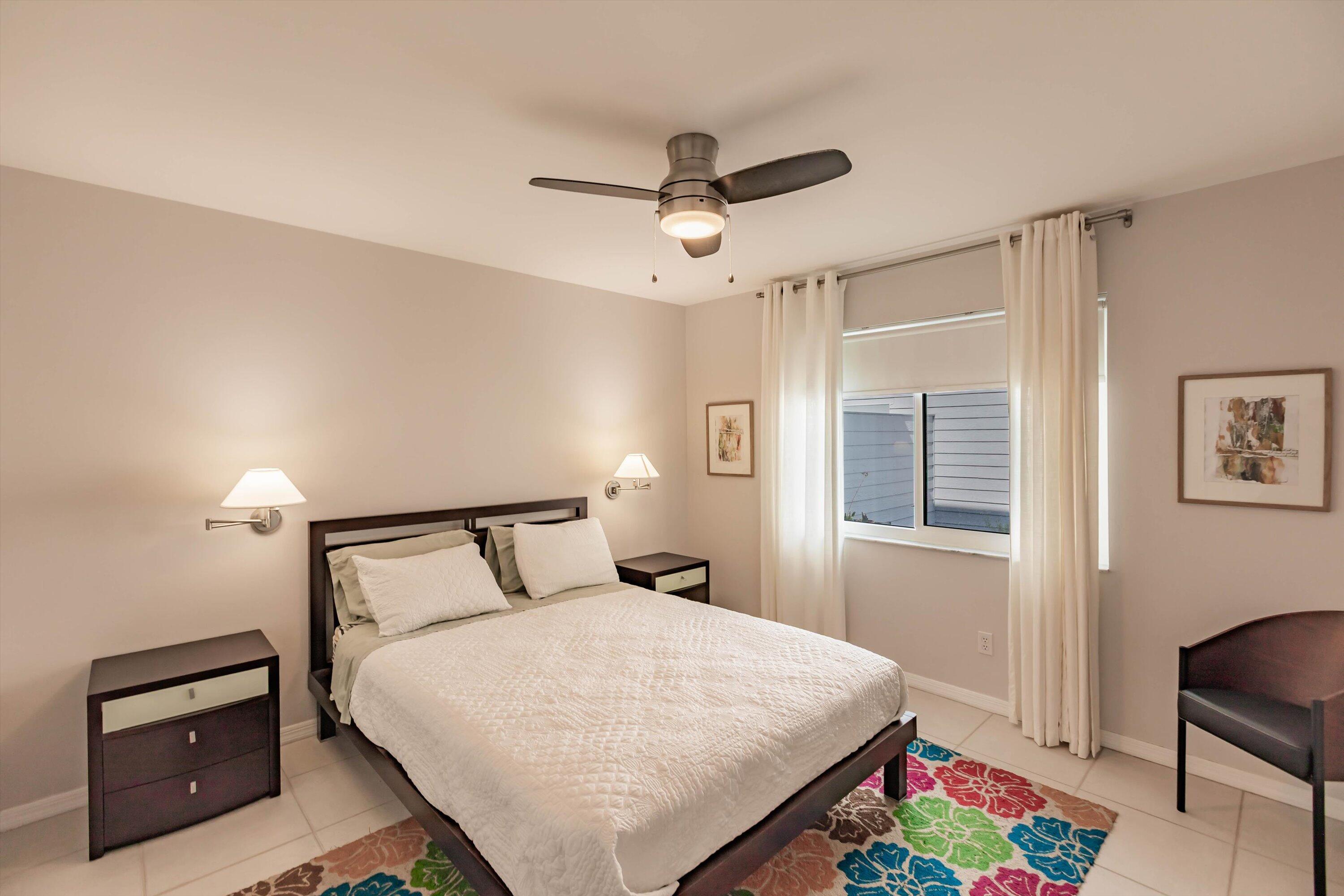 6115 Southeast Georgetown Place, Unit 1006 Hobe Sound, FL 33455 - Photo 23 of 68 a bedroom with a bed and a chandelier