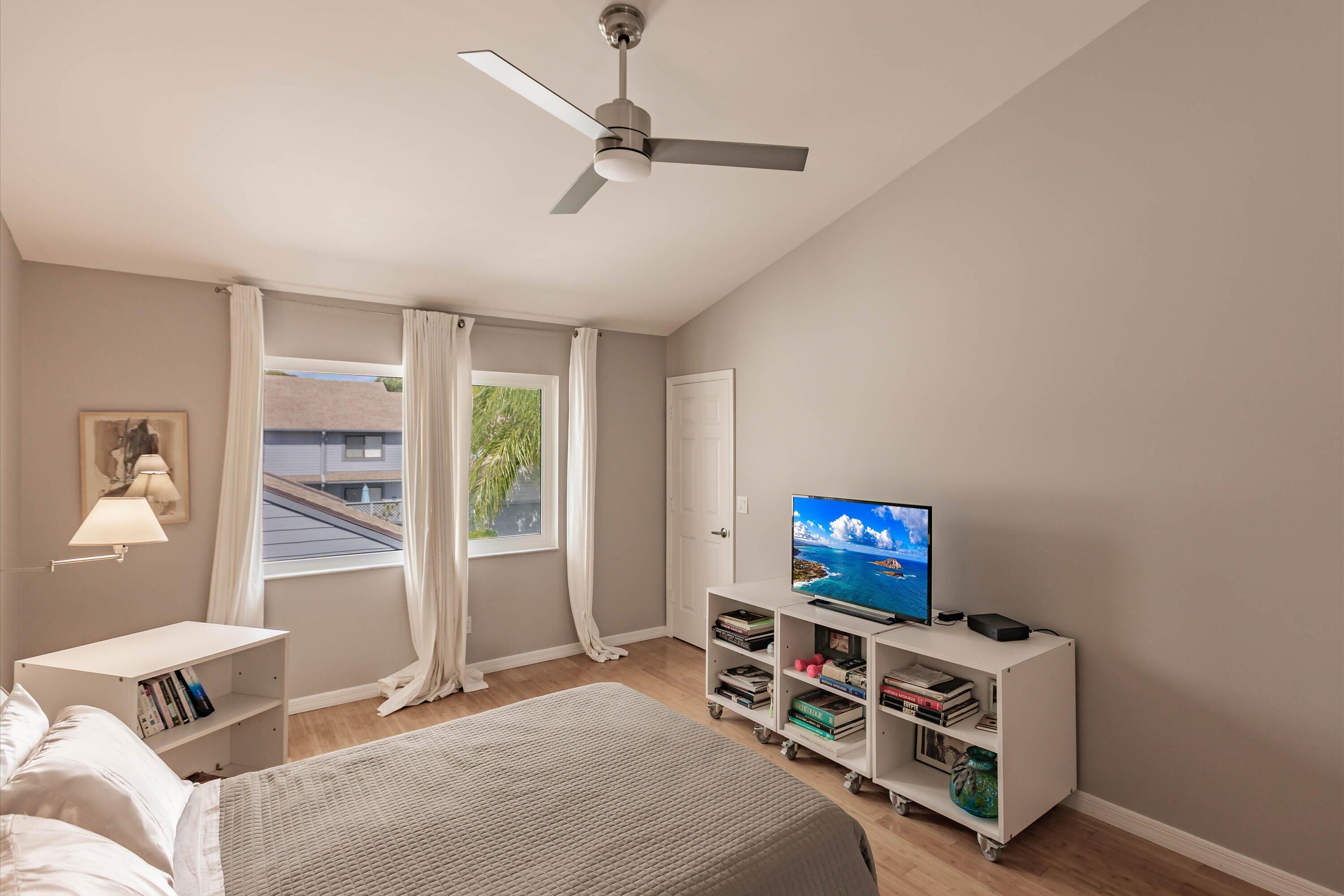6115 Southeast Georgetown Place, Unit 1006 Hobe Sound, FL 33455 - Photo 34 of 68 a bedroom with furniture and a flat screen tv