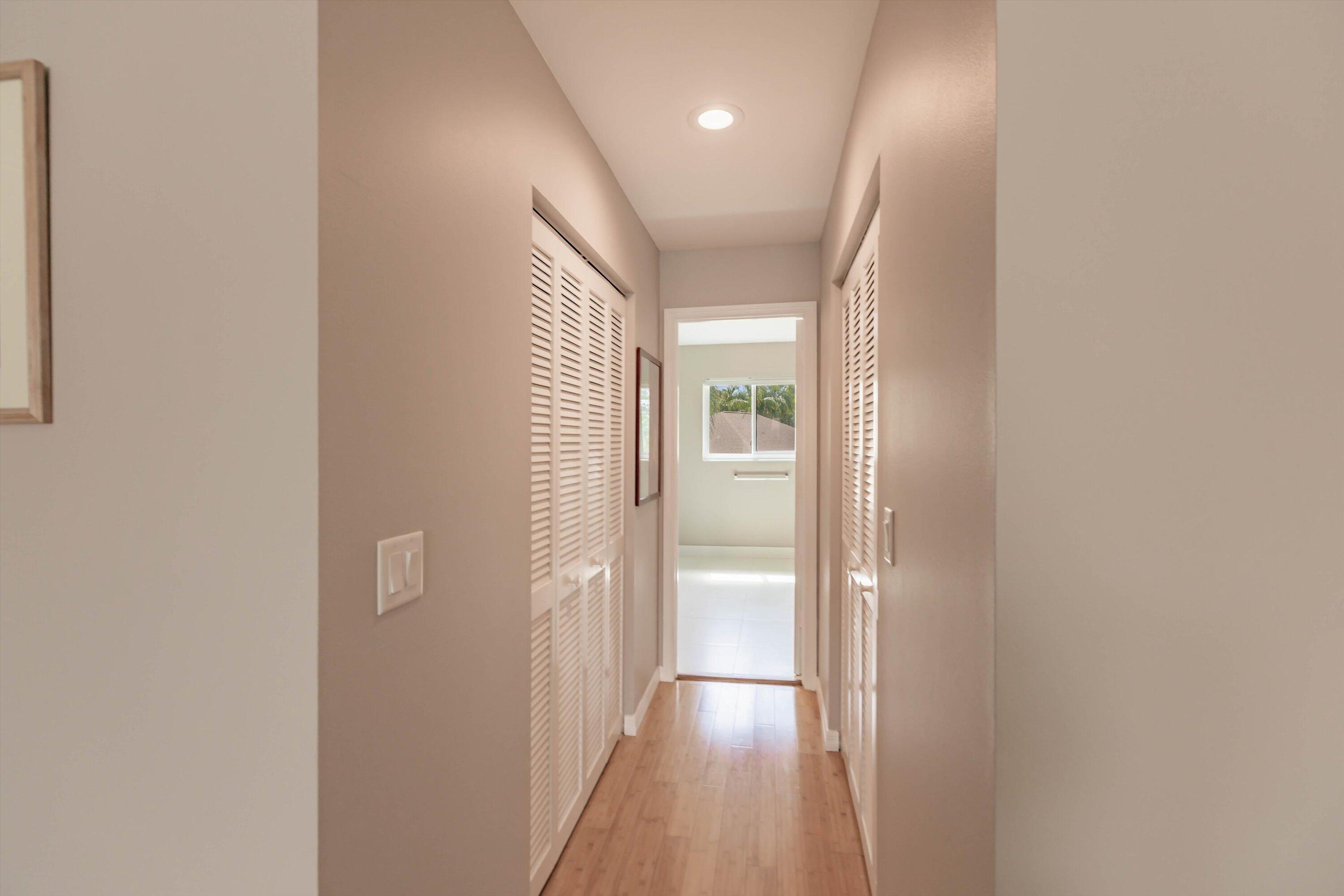6115 Southeast Georgetown Place, Unit 1006 Hobe Sound, FL 33455 - Photo 37 of 68 a view of hallway with a large window and wooden floor
