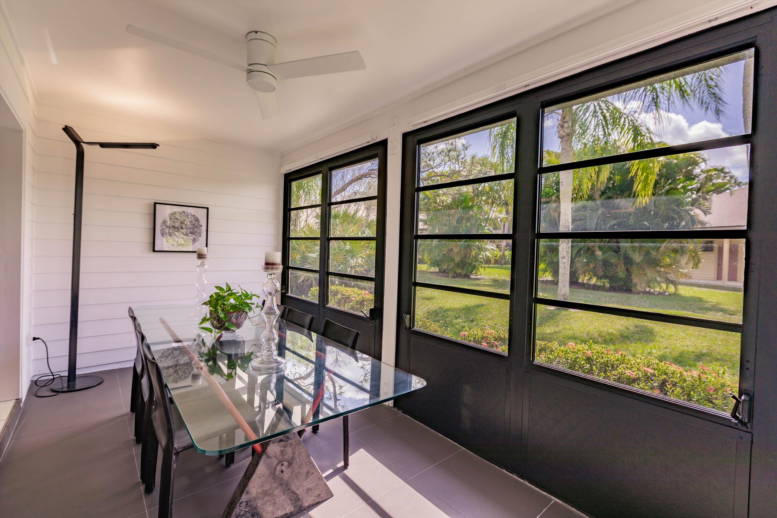 6115 Southeast Georgetown Place, Unit 1006 Hobe Sound, FL 33455 - Photo 41 of 68 a view of a dining room with furniture window and wooden floor