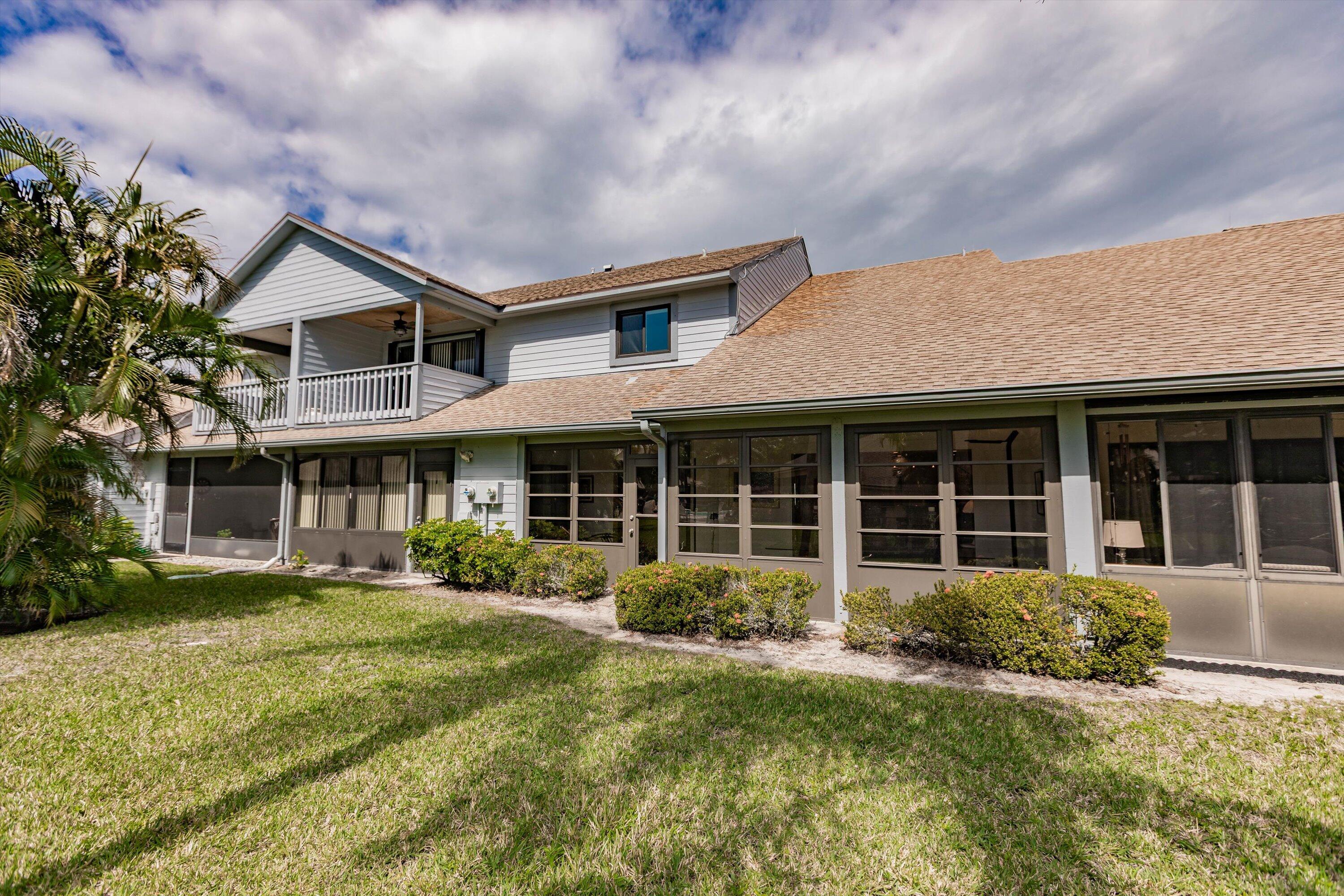 6115 Southeast Georgetown Place, Unit 1006 Hobe Sound, FL 33455 - Photo 46 of 68 a front view of a house with garden
