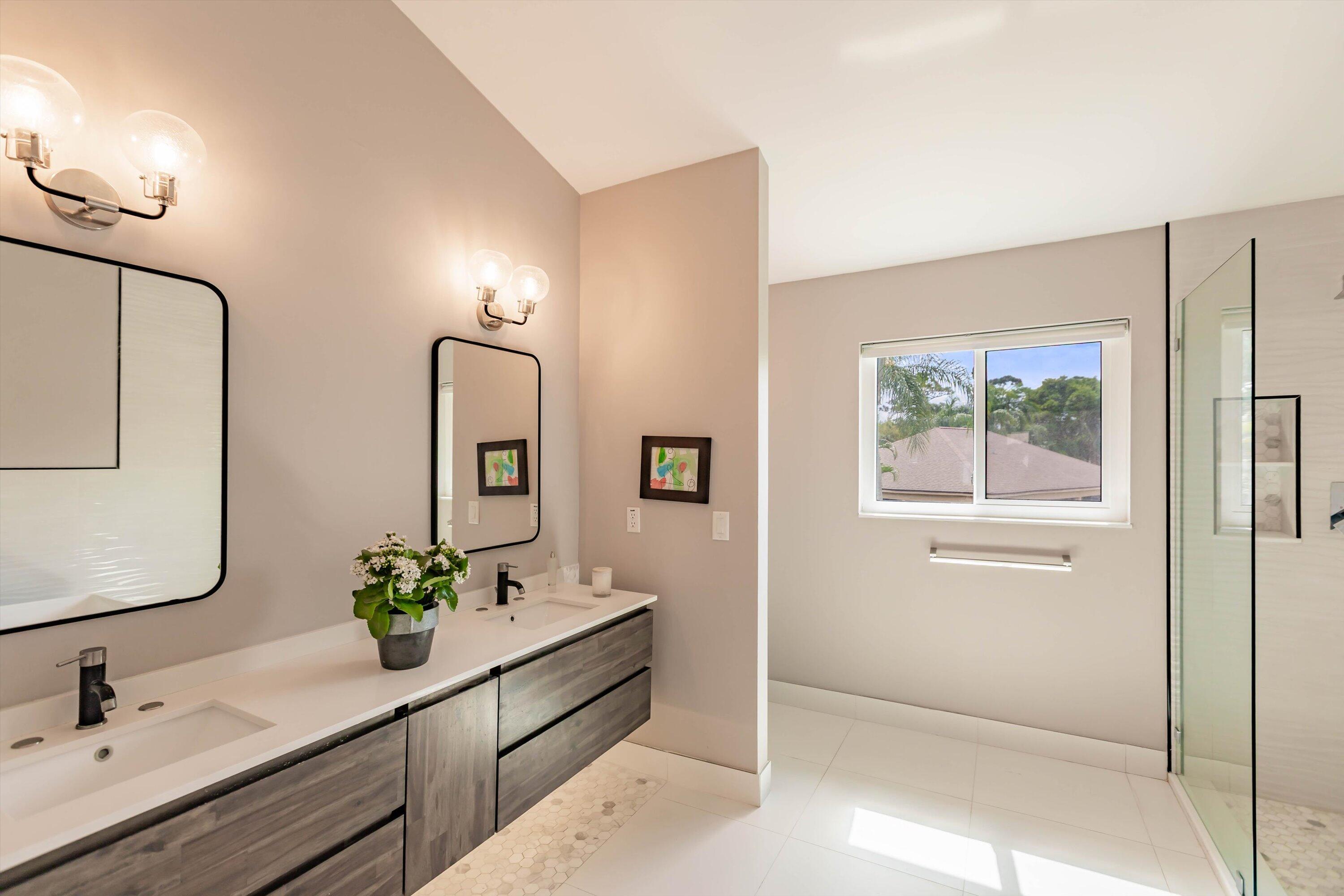 6115 Southeast Georgetown Place, Unit 1006 Hobe Sound, FL 33455 - Photo 6 of 68 a bathroom with a double vanity sink and a mirror