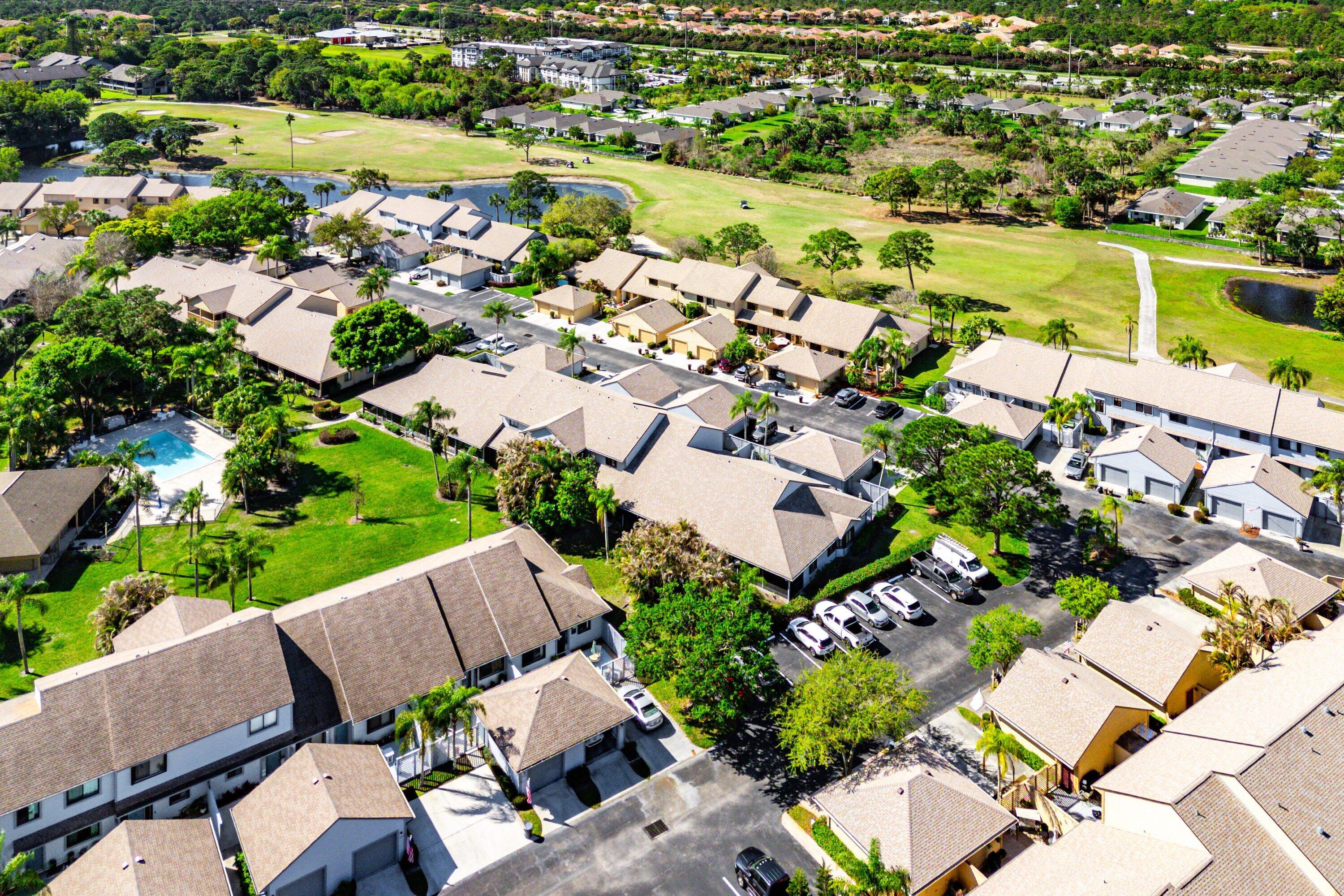 6115 Southeast Georgetown Place, Unit 1006 Hobe Sound, FL 33455 - Photo 62 of 68 an aerial view of a house with a garden and lake view