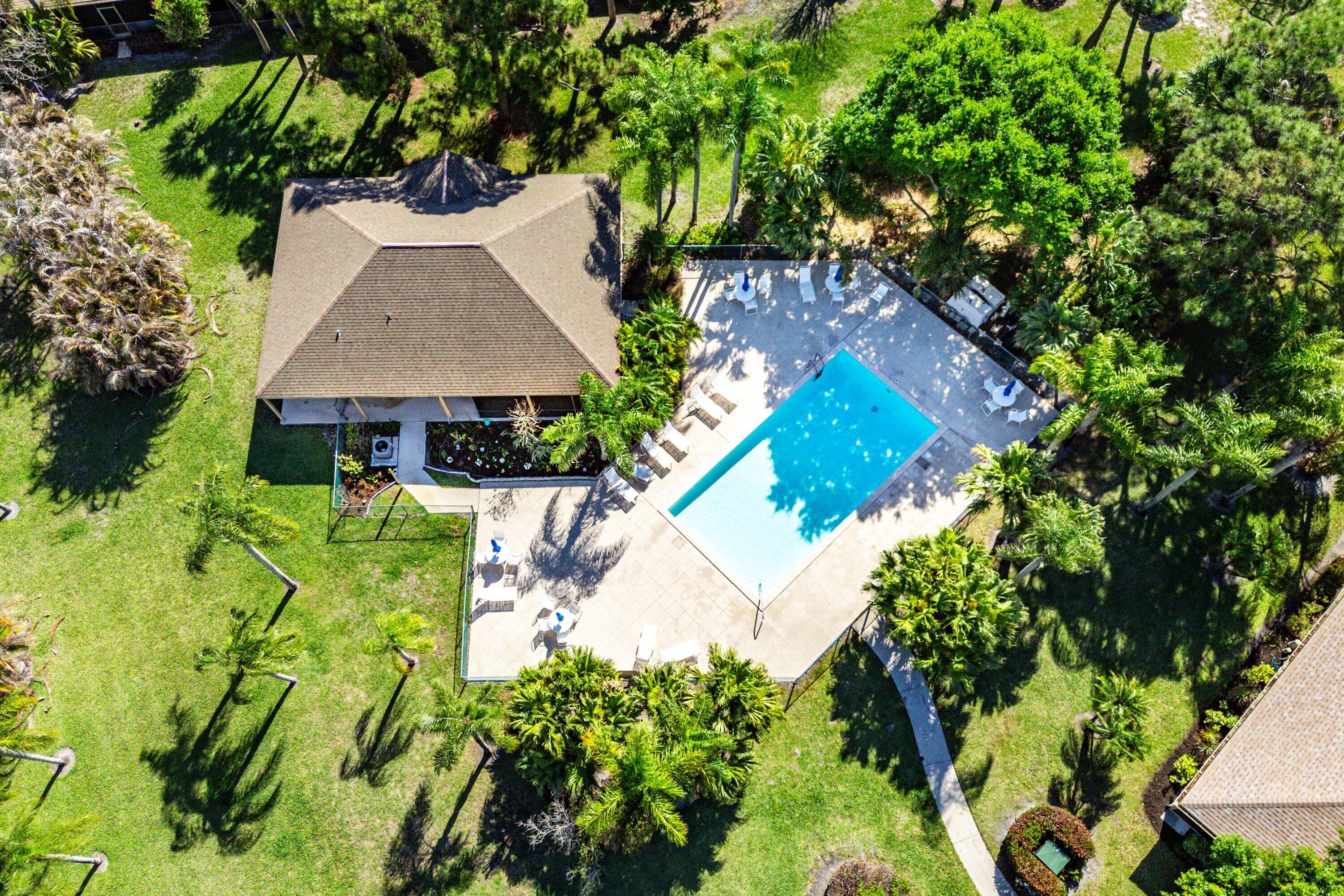 6115 Southeast Georgetown Place, Unit 1006 Hobe Sound, FL 33455 - Photo 65 of 68 an aerial view of a house with swimming pool and garden