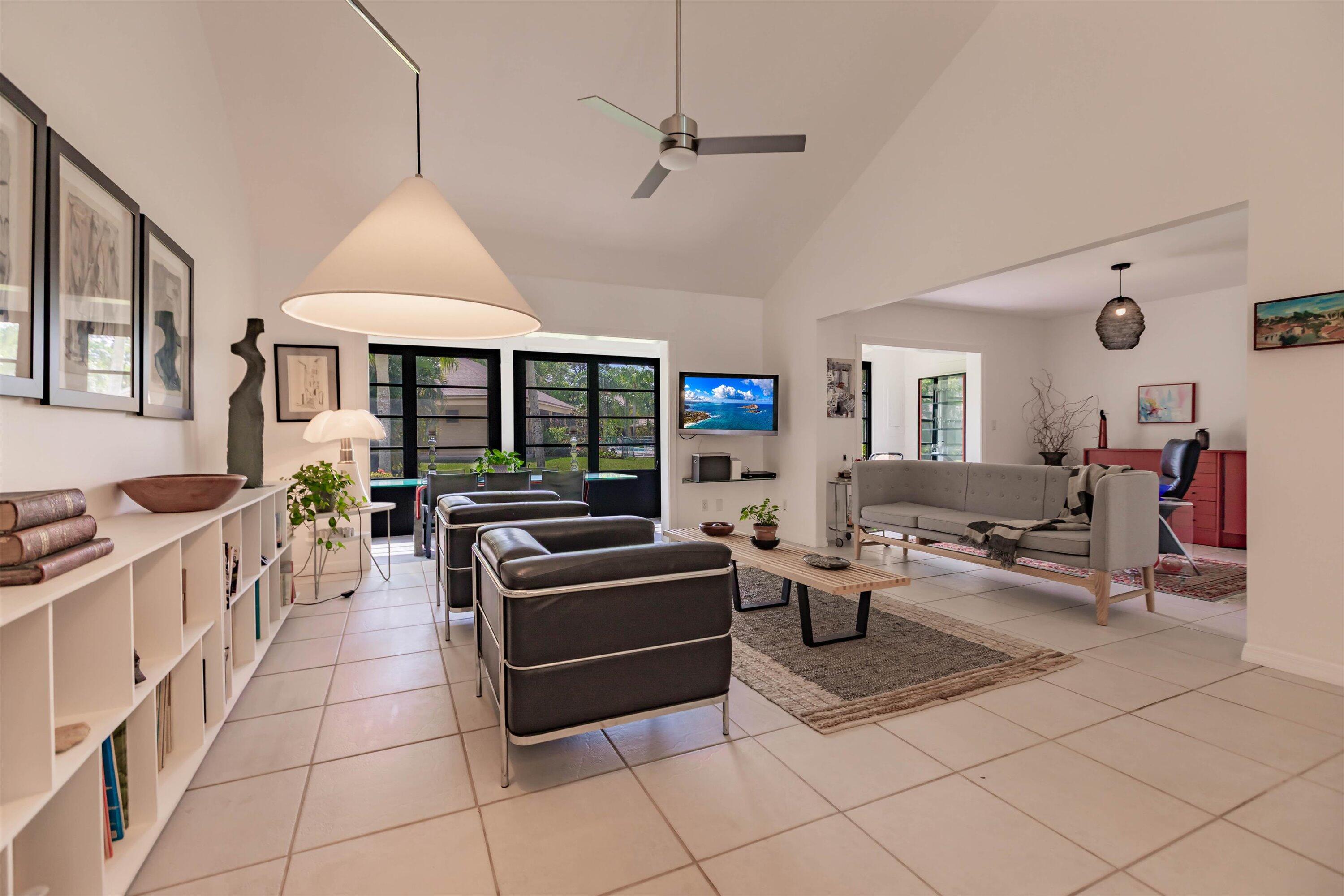 6115 Southeast Georgetown Place, Unit 1006 Hobe Sound, FL 33455 - Photo 10 of 68 a living room with furniture a flat screen tv and a window
