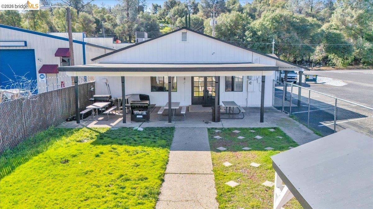 14326 Tuolumne Road Sonora, CA 95370 - Photo 16 of 48 a view of a patio with table and chairs potted plants and large tree