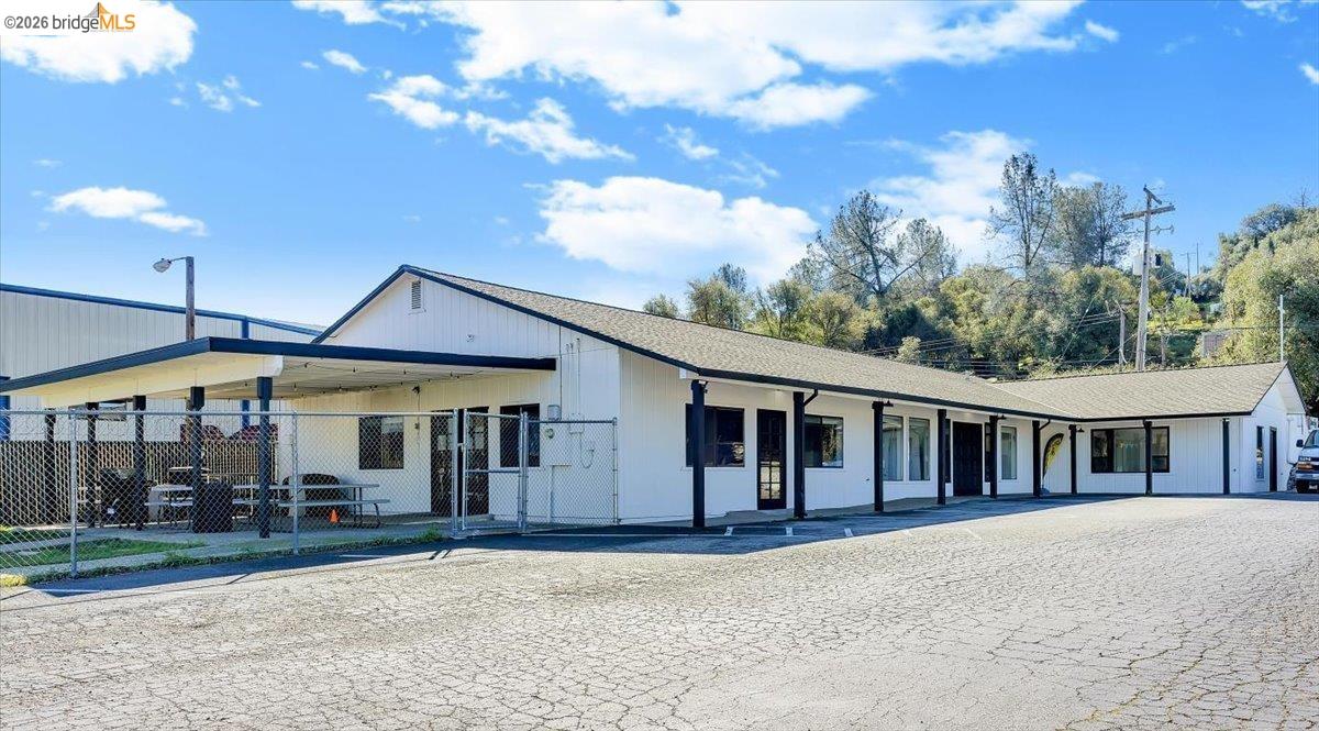 14326 Tuolumne Road Sonora, CA 95370 - Photo 3 of 48 a view of a white house with large windows and a small yard