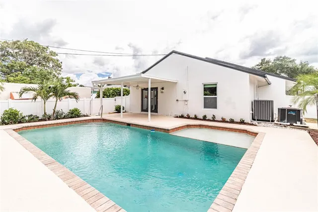 a swimming pool with outdoor seating and yard
