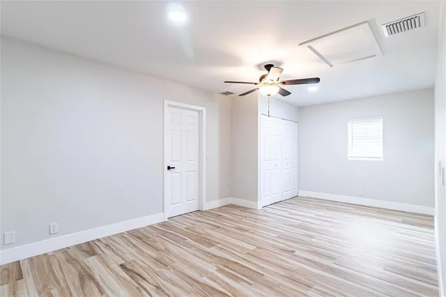 a view of a room with a ceiling fan and a hardwood floor