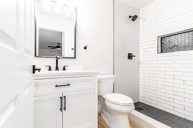 a bathroom with a sink vanity mirror and toilet