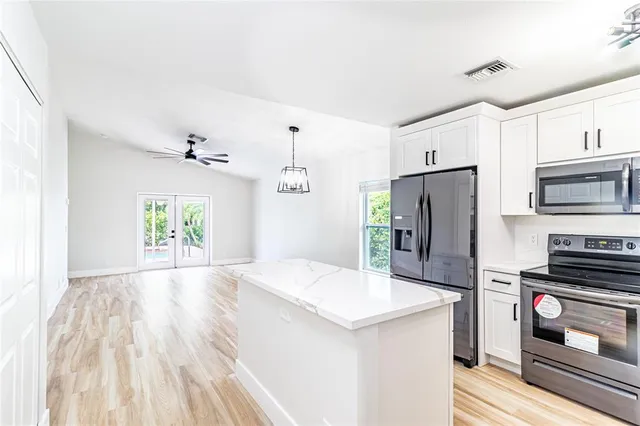 a kitchen with granite countertop a refrigerator and a stove top oven