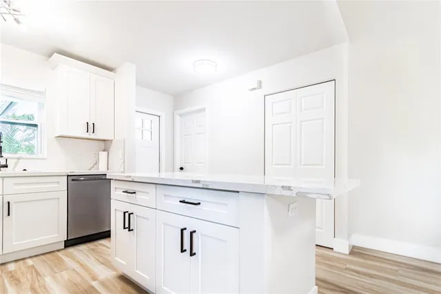 a kitchen with granite countertop white cabinets and white appliances