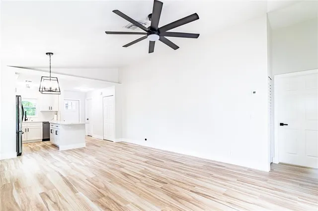 a view of a room with wooden floor and a ceiling fan