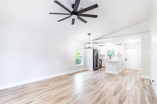 a view of a room with wooden floor and a ceiling fan