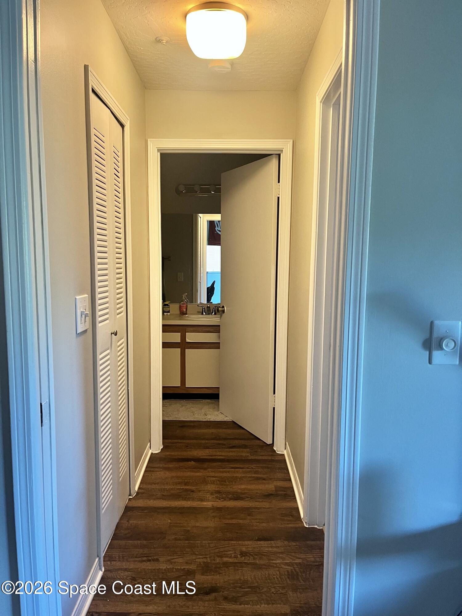 7667 North Wickham Road, Unit 1118 Melbourne, FL 32940 - Photo 10 of 26 a view of a hallway with wooden floor and a living room