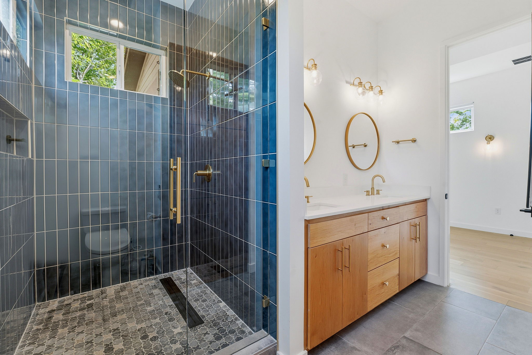 1707 Deloney Street, Unit 2 Austin, TX 78721 - Photo 18 of 26 A well-lit bathroom with a glass-enclosed shower and a modern double vanity.