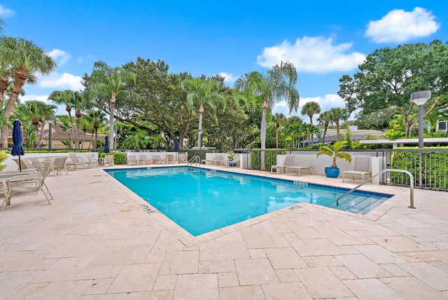 a view of a swimming pool with a patio and a yard