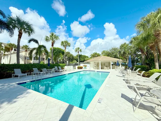 a view of a house with pool and chairs