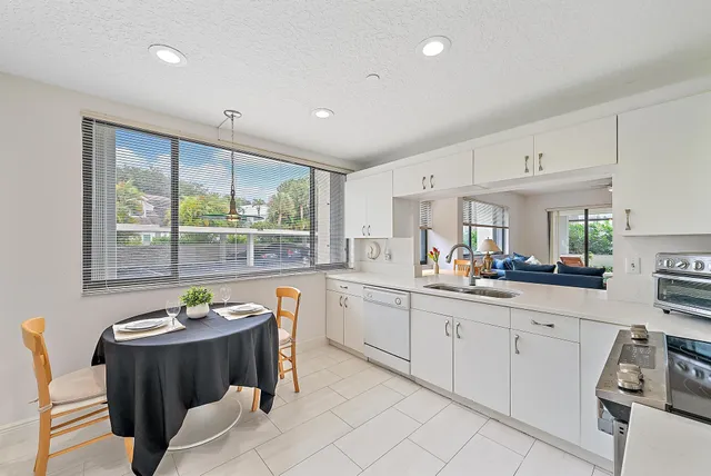 a large white kitchen with a large window