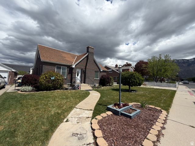 287 100 North Orem, UT 84057 - Photo 2 of 18 View of front of property featuring brick siding, a front yard, a chimney, and a shingled roof