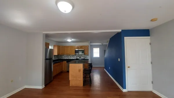 a kitchen with granite countertop wooden floors and wooden cabinets