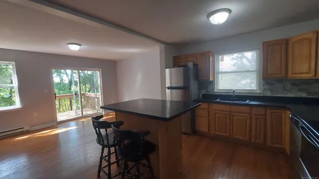 a kitchen with stainless steel appliances a sink a stove a microwave a refrigerator and cabinets