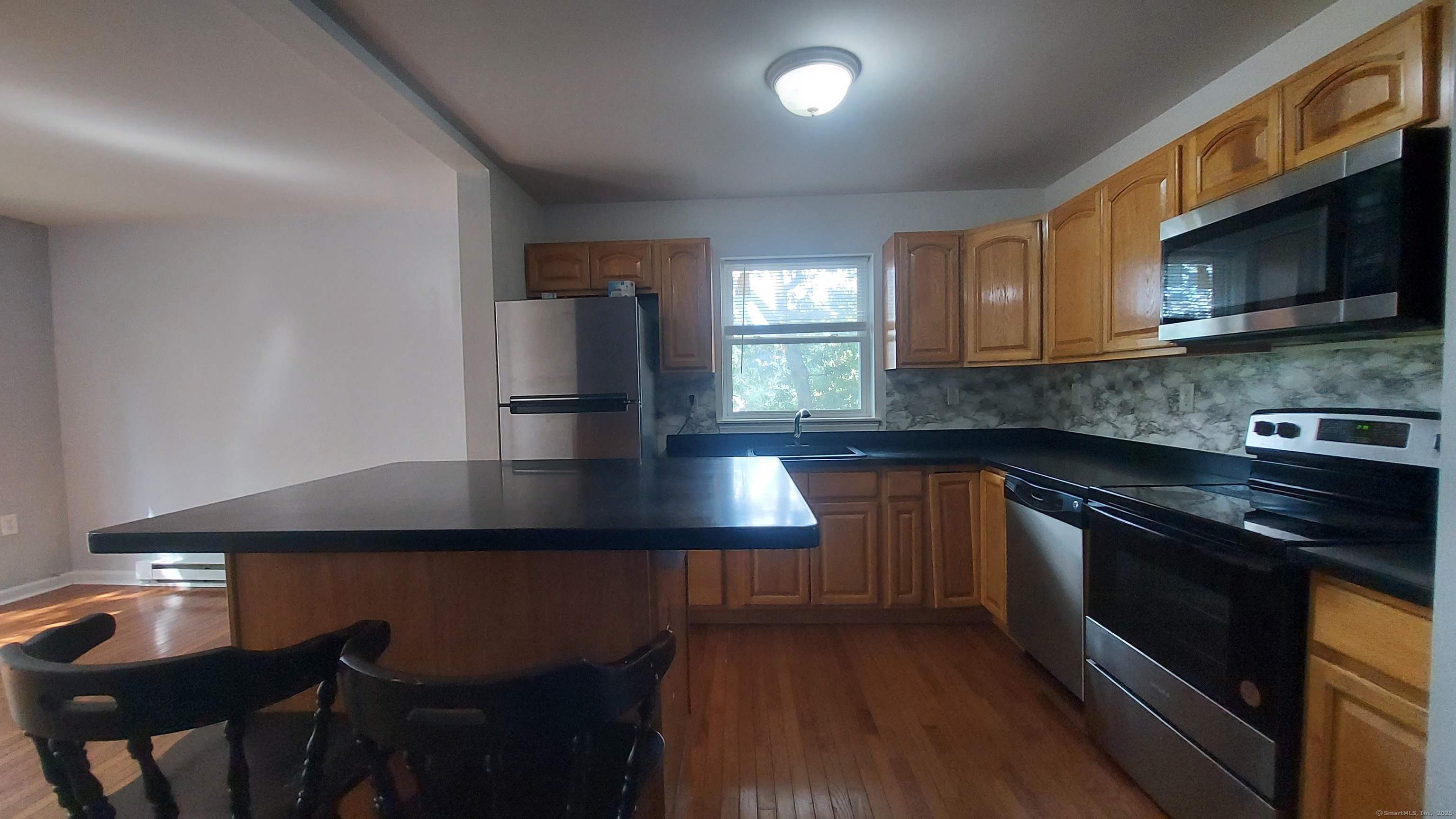 10 Hillcrest Street, Unit B Norwich, CT 06360 - Photo 16 of 34 a kitchen with stainless steel appliances a sink a stove a microwave a refrigerator and cabinets