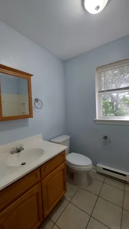 a bathroom with a toilet sink vanity and mirror