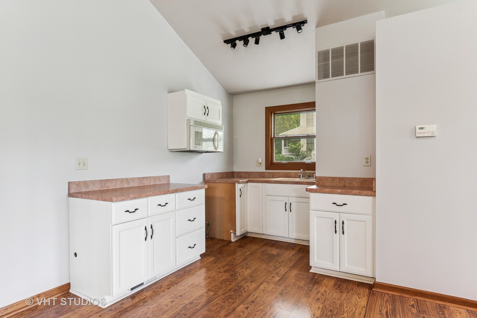 62 Foxhurst Lane Newark, IL 60541 - Photo 26 of 36 a hall with kitchen island white cabinets and wooden floor