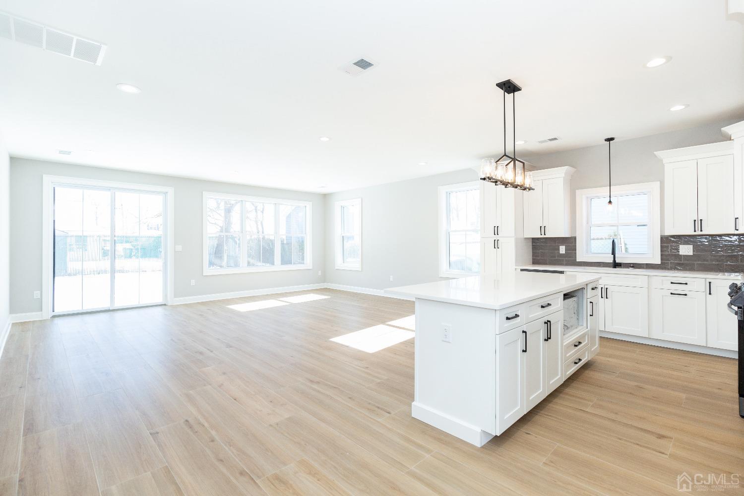 60 Brookville Road Edison, NJ 08817 - Photo 12 of 56 a large kitchen with stainless steel appliances granite countertop a stove a sink and white cabinets with wooden floor