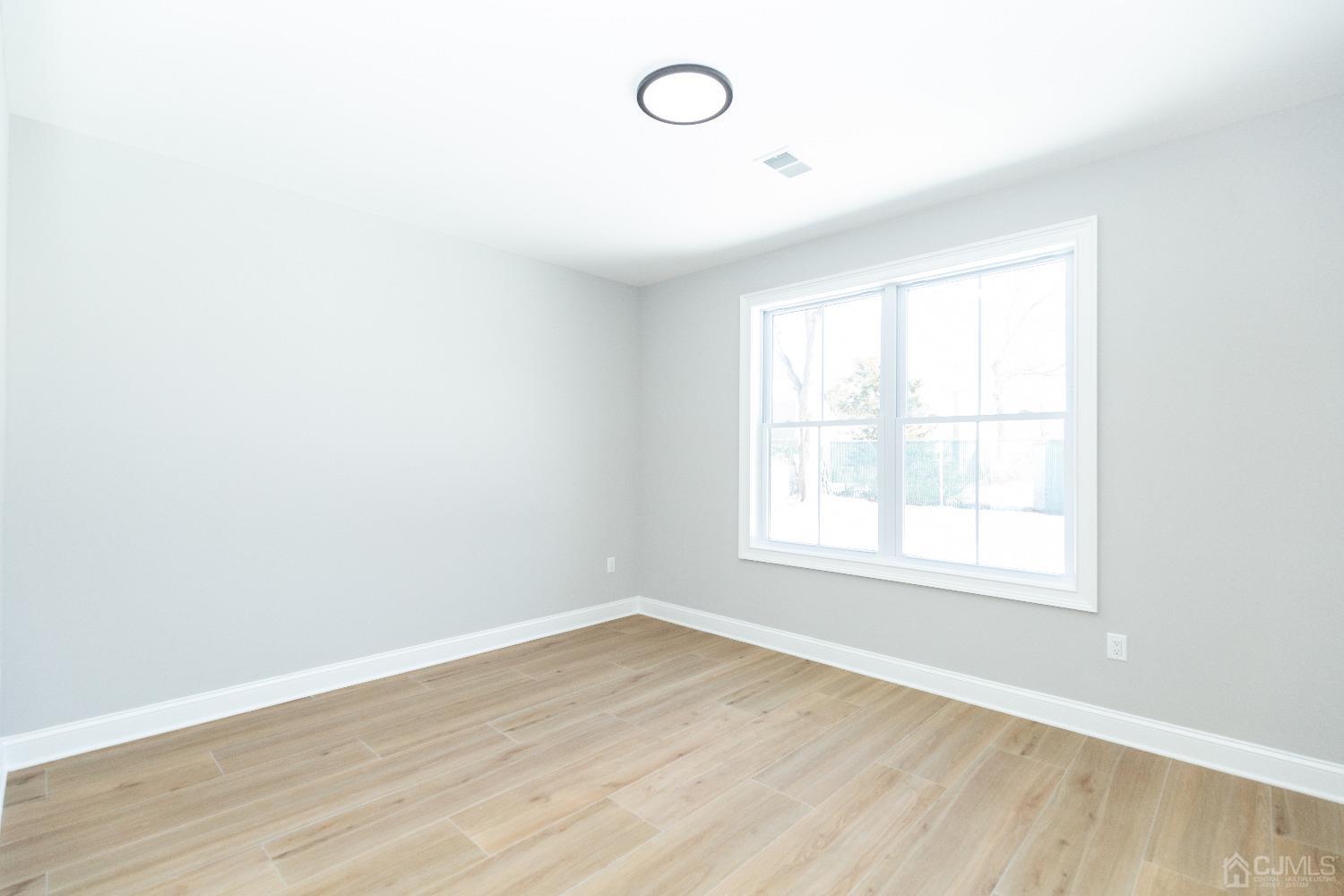 60 Brookville Road Edison, NJ 08817 - Photo 21 of 56 an empty room with wooden floor and window