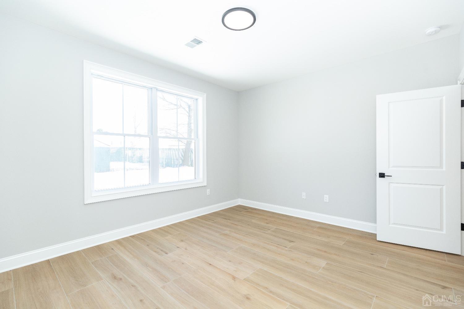 60 Brookville Road Edison, NJ 08817 - Photo 24 of 56 an empty room with wooden floor and windows